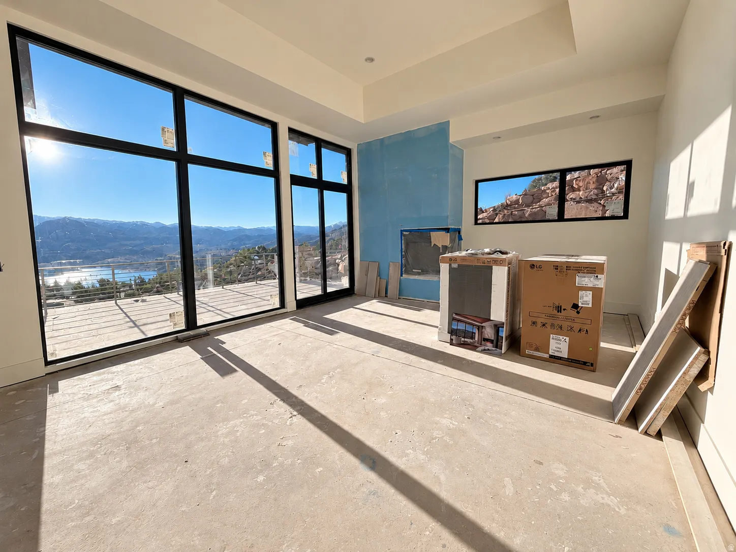 Primary Suite. Floor-to-ceiling windows, panoramic mountain scenery, lake scenery, contemporary fireplace structure, and recessed lighting.