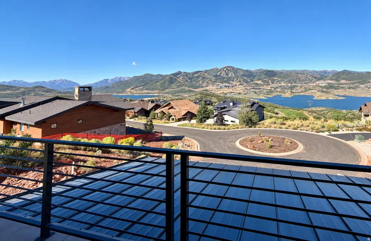 Expansive mountain and lake scenery with a contemporary metal railing