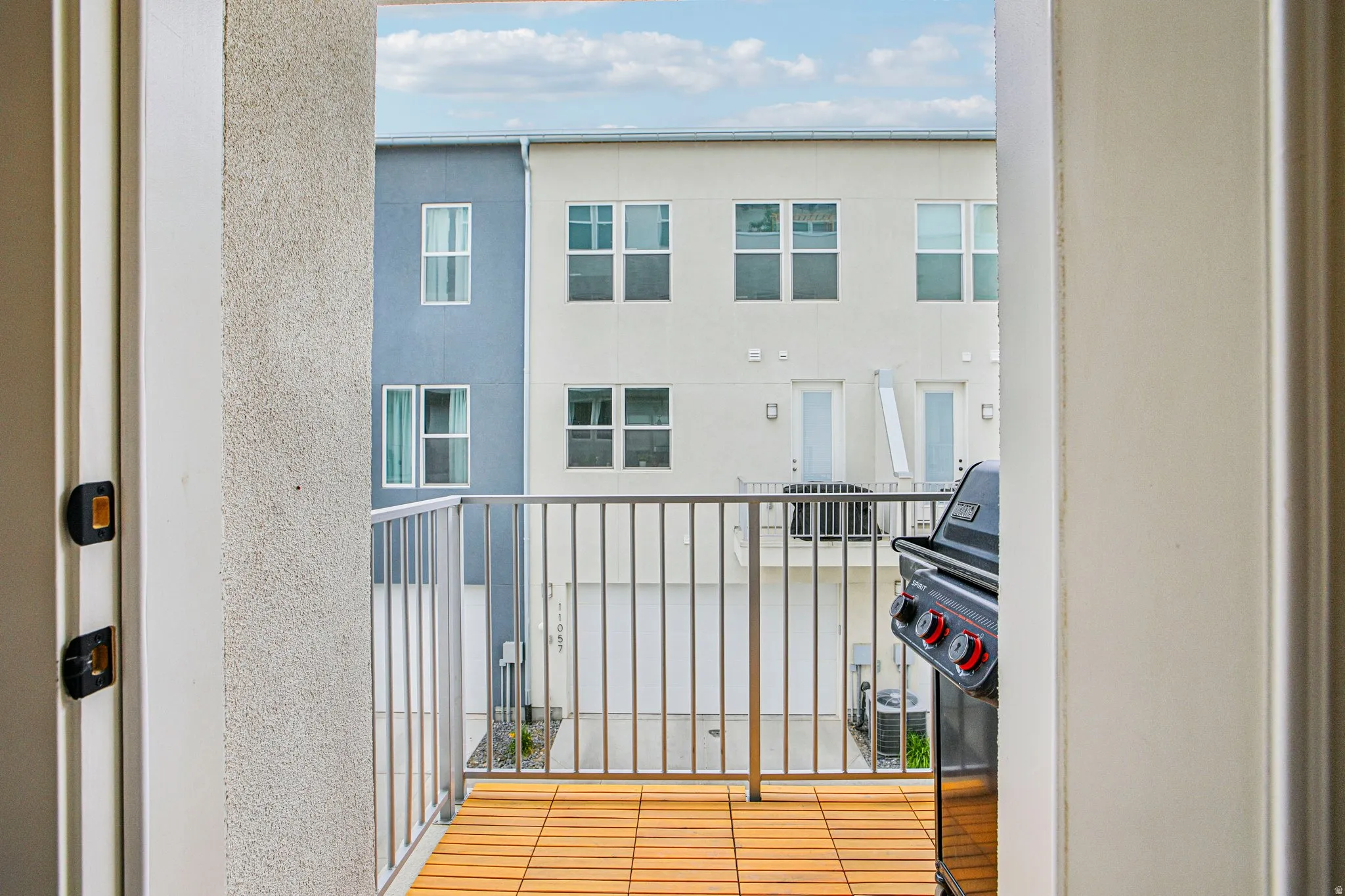 Outdoor balcony with wood-finish flooring and metal railing