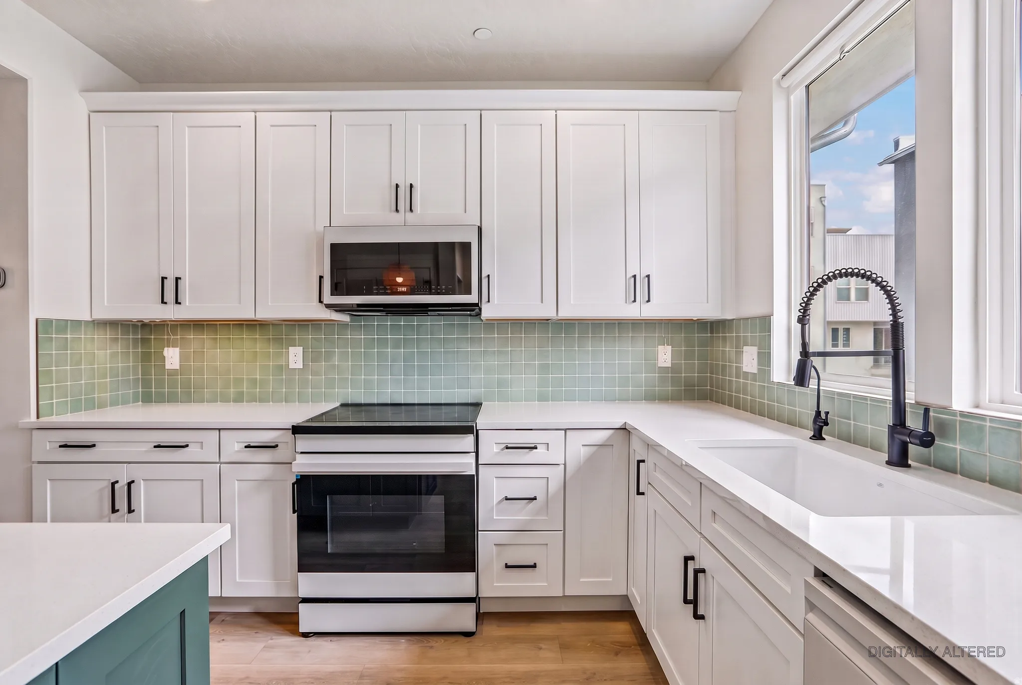 White shaker cabinetry with matte black hardware, light green tile backsplash, white countertops, and wood-finish flooring