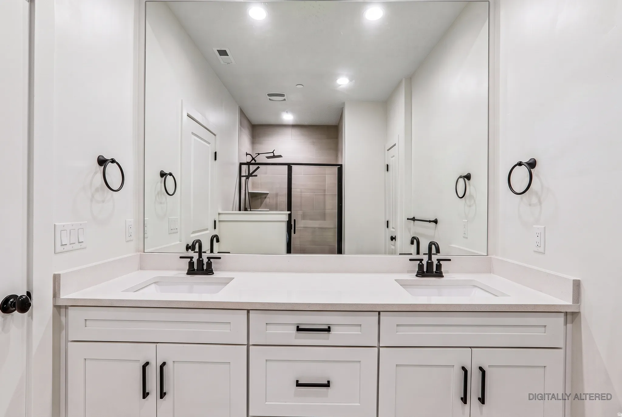 Double vanity with white cabinetry, matte black hardware, integrated sinks, and a large wall-mounted mirror