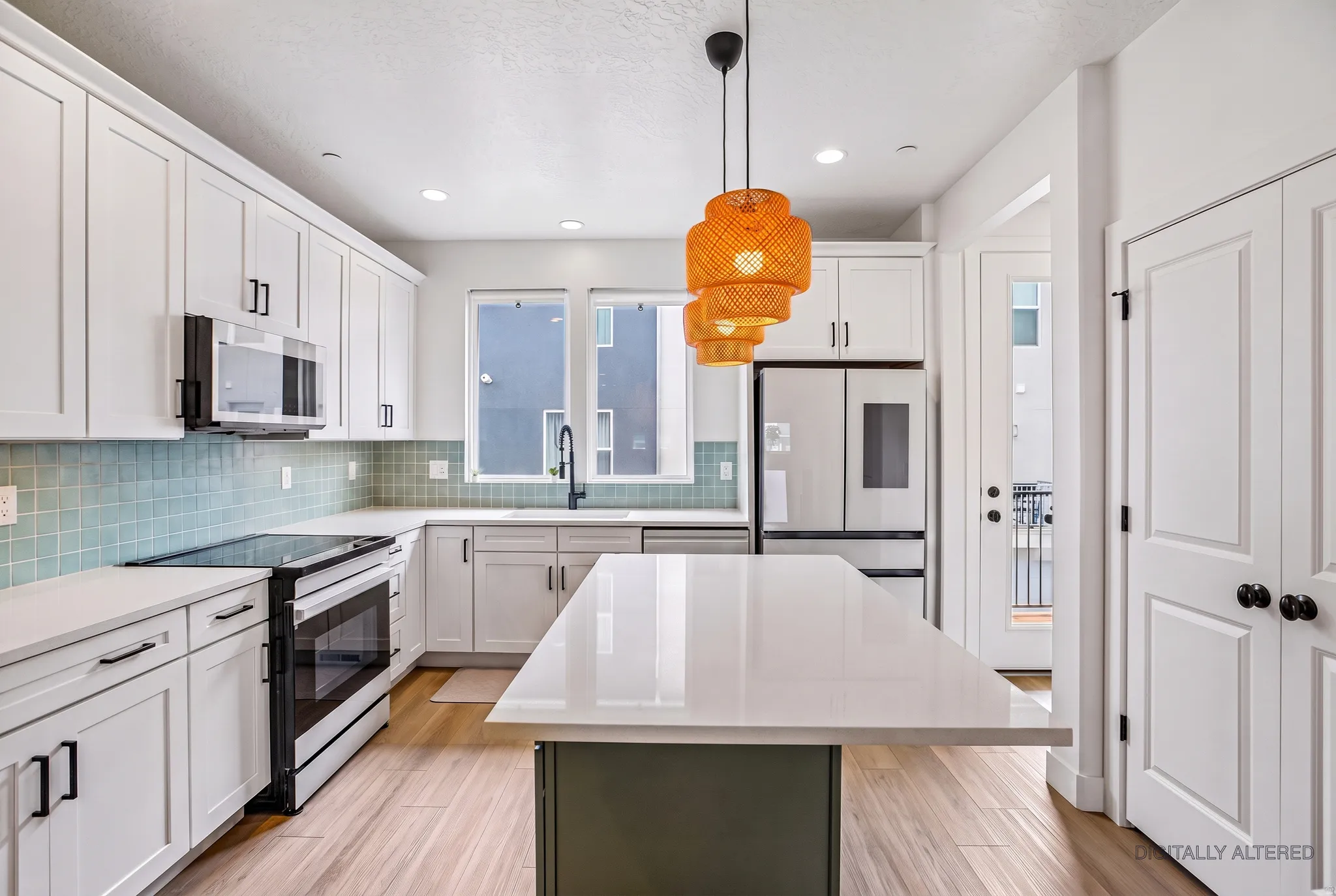 Kitchen featuring white cabinetry, light-toned wood-finish flooring, a central island with a solid surface countertop, a tiled backsplash, and recessed lighting