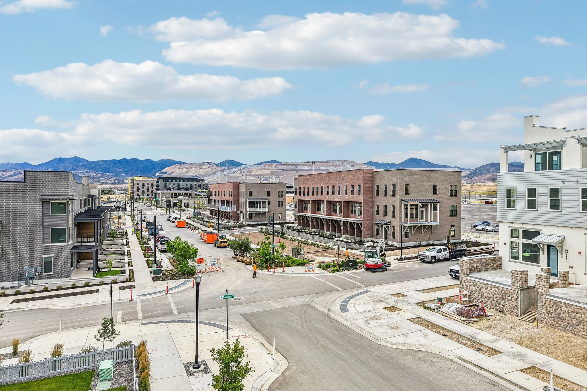 Modern multi-story buildings featuring varied exterior finishes including brick, horizontal siding, and stone accents
