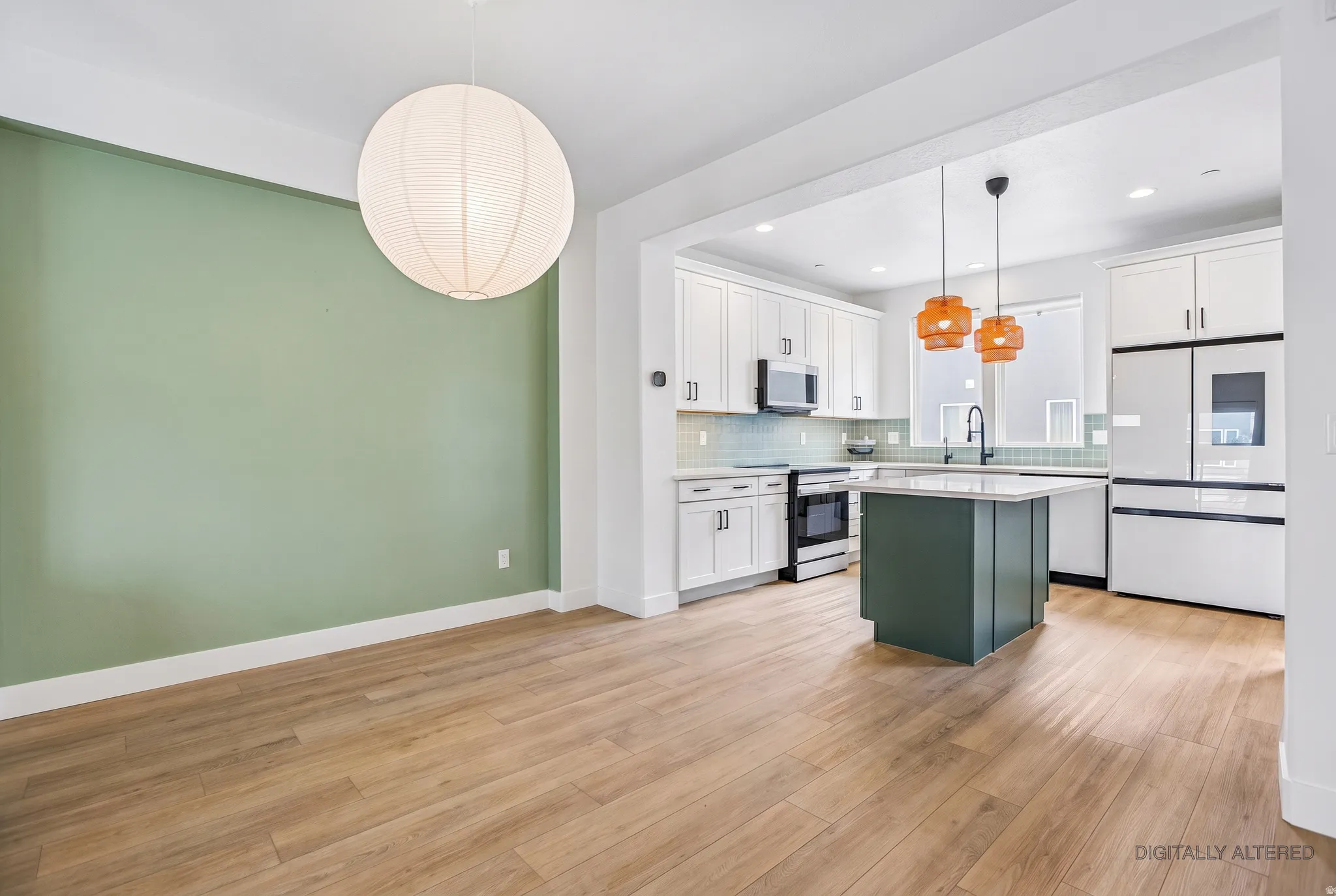 Hardwood-finish flooring throughout, featuring a kitchen with a central island, white cabinetry, and stainless steel appliances