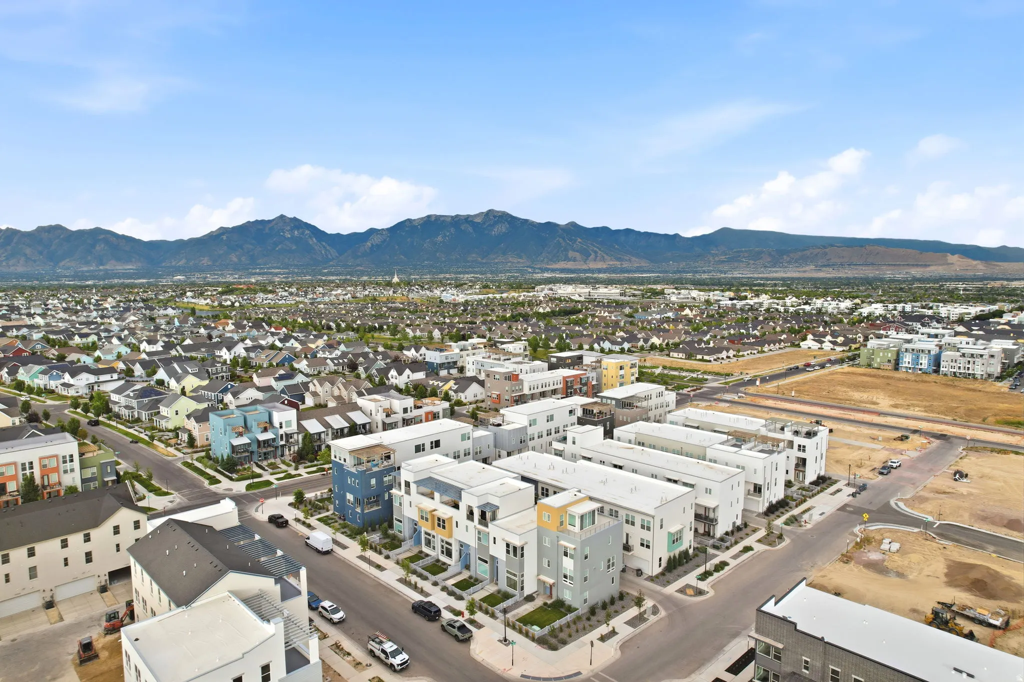 Aerial view of a modern residential community featuring newly constructed homes with contemporary architecture, situated on manicured grounds with established landscaping