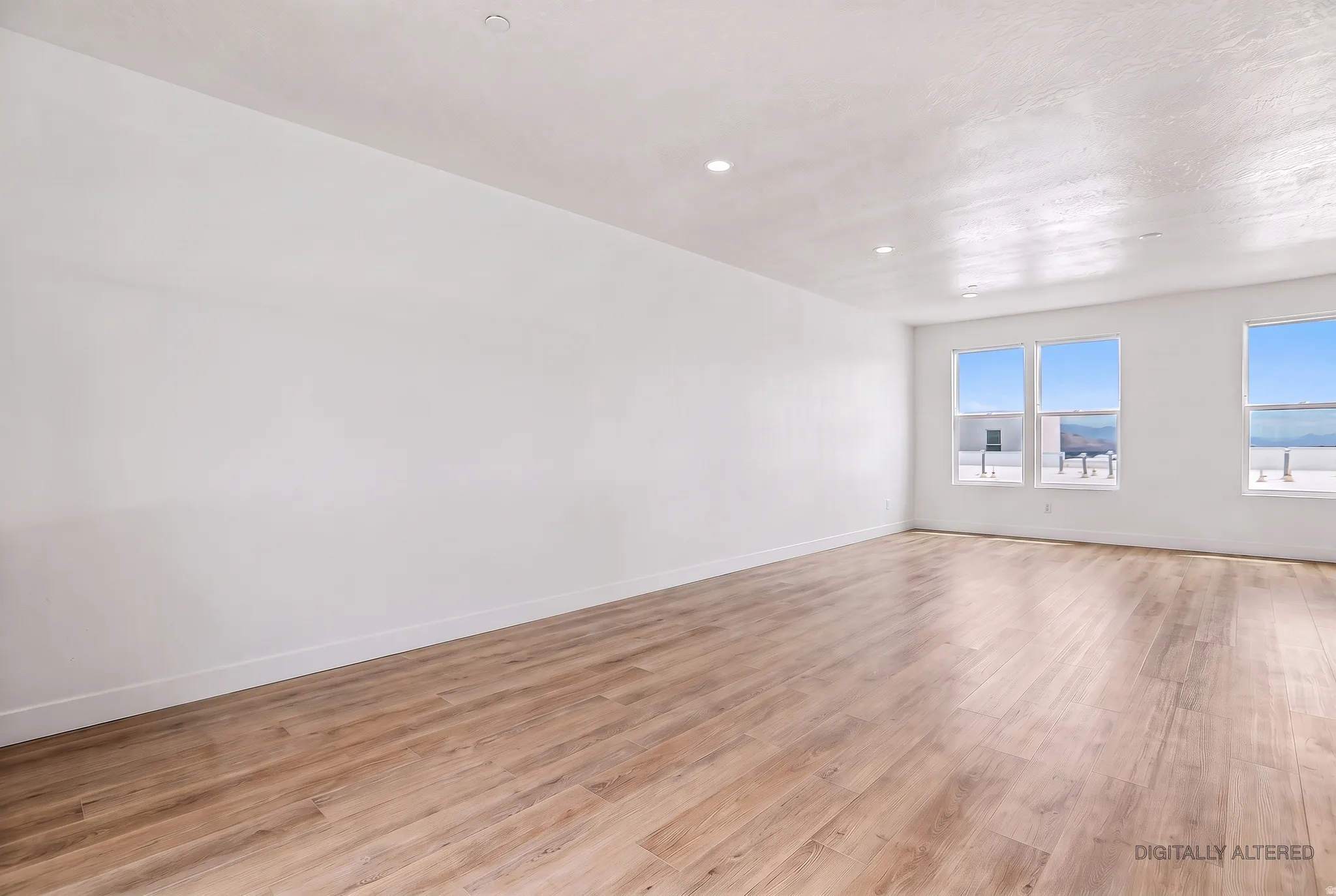 Bright interior with recessed lighting, light wood-finish flooring, and multiple windows