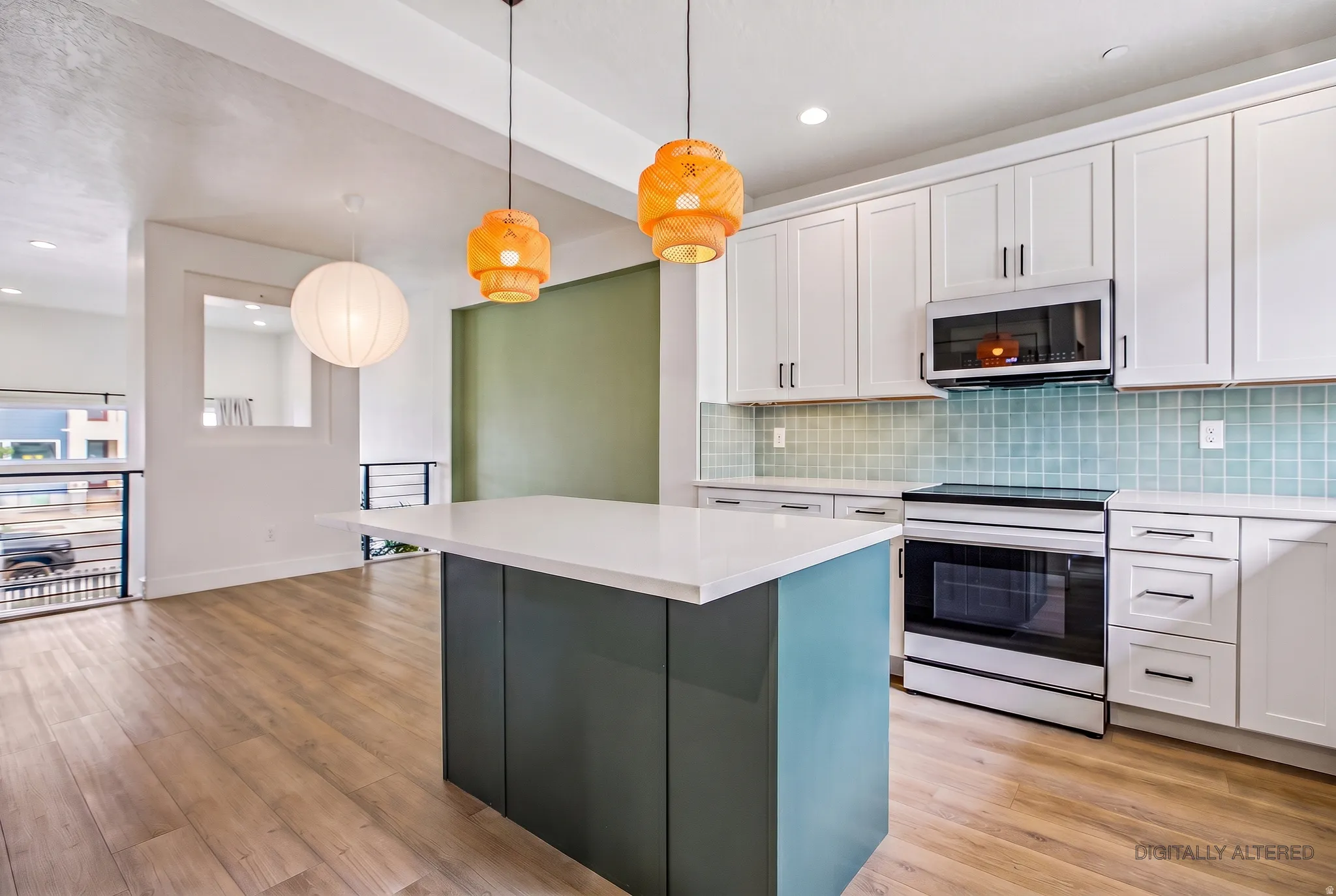 Kitchen featuring a central island with white countertop, light wood-finish flooring, white cabinetry, integrated stainless steel appliances, and a tiled backsplash