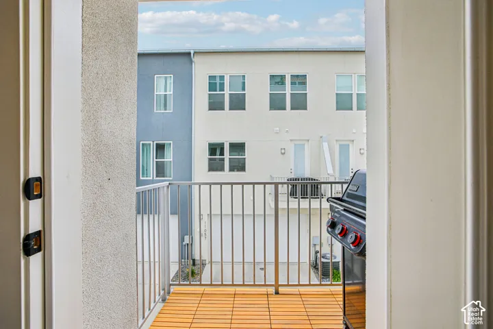 Outdoor balcony with wood-finish flooring and metal railing