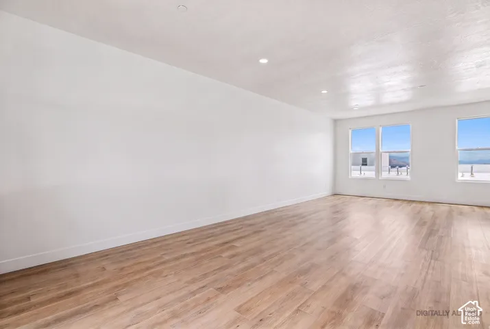 Bright interior with recessed lighting, light wood-finish flooring, and multiple windows