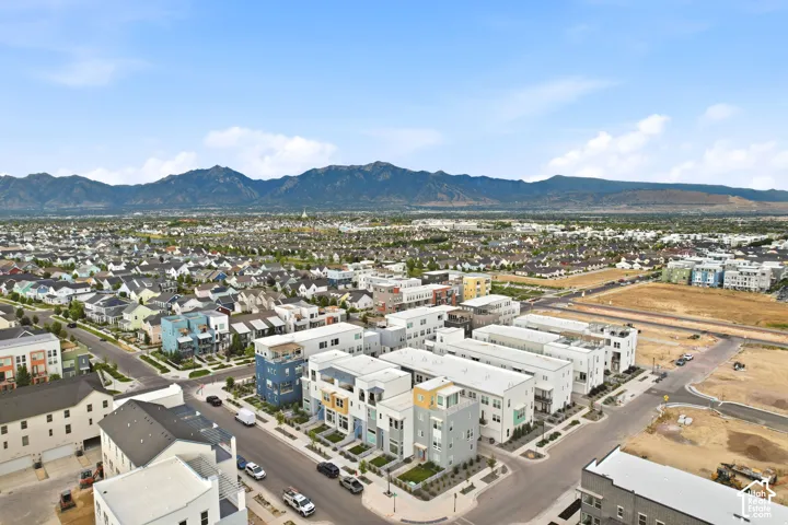 Aerial view of a modern residential community featuring newly constructed homes with contemporary architecture, situated on manicured grounds with established landscaping