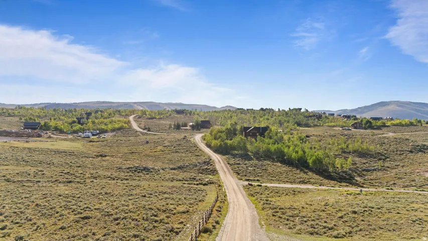 Expansive landscape featuring rolling hills and distant mountains under a clear sky
