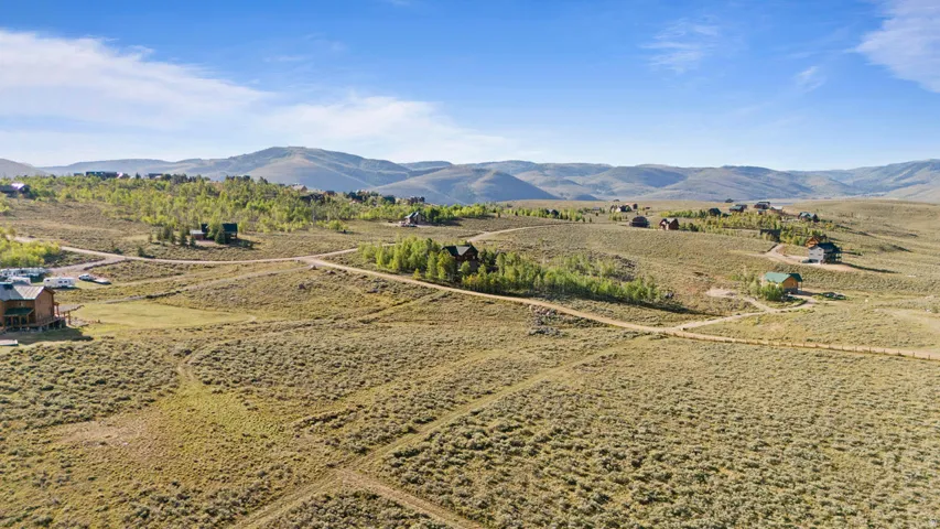 Expansive land parcel with surrounding established residences and distant mountain terrain