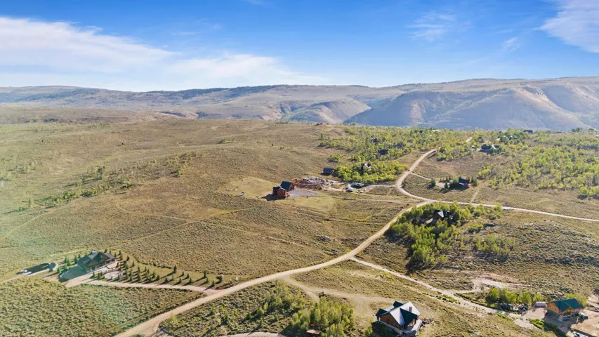Expansive mountain landscape with scattered residential structures and unpaved roads