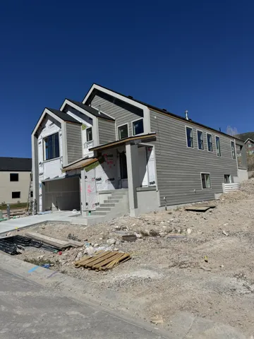Gray siding exterior with multiple window configurations and a concrete driveway
