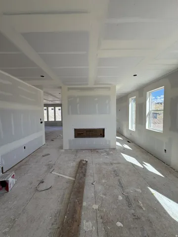 Recessed fireplace opening, multiple windows, and a coffered ceiling