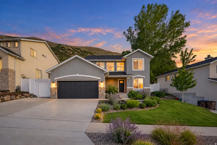 Contemporary stucco exterior with a dark garage door, stone accents, and a concrete driveway