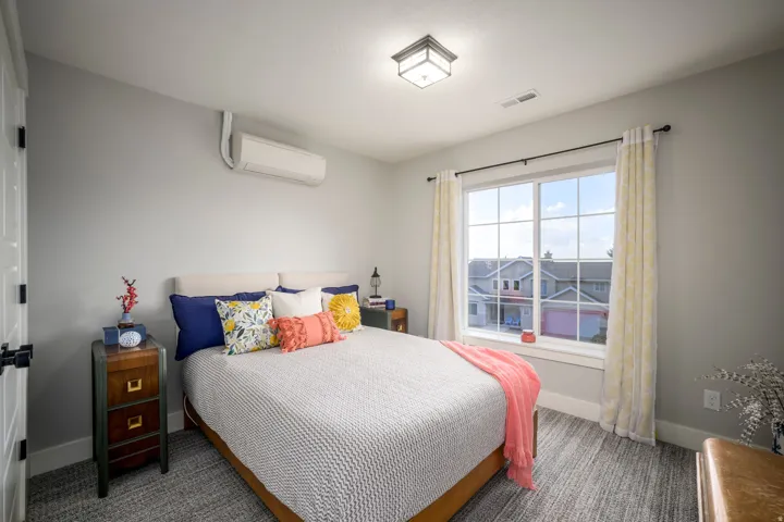 Wall-mounted air conditioning unit, recessed ceiling lighting, large window with grid pattern, and gray wall paint