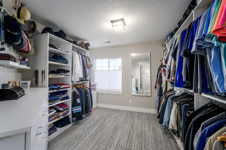 Built-in custom closet system with extensive shelving, multiple hanging rods, and integrated drawers