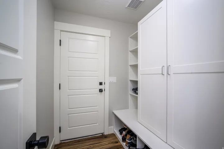 Wood-finish flooring with white built-in cabinetry and shelving