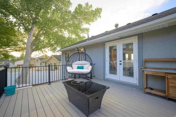 Outdoor deck with composite decking, black metal railing, and white French doors