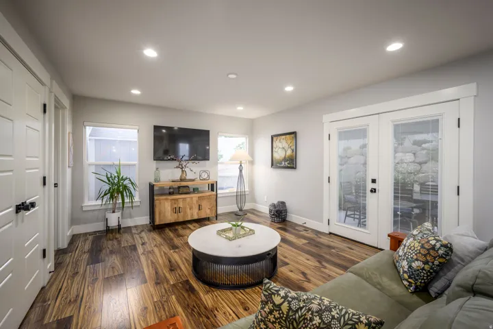 Recessed ceiling lighting, wood-finish flooring, white panel doors, white trim, and a glass-paneled double door