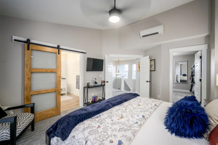Recessed ceiling featuring a ceiling fan, light gray wall paint, and a wall-mounted mini-split system