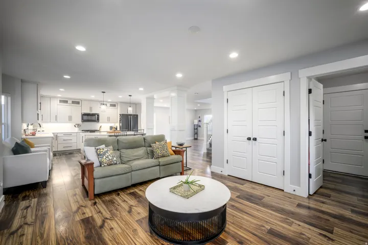 Open-concept living area featuring wood-finish flooring, recessed lighting, and white paneled doors