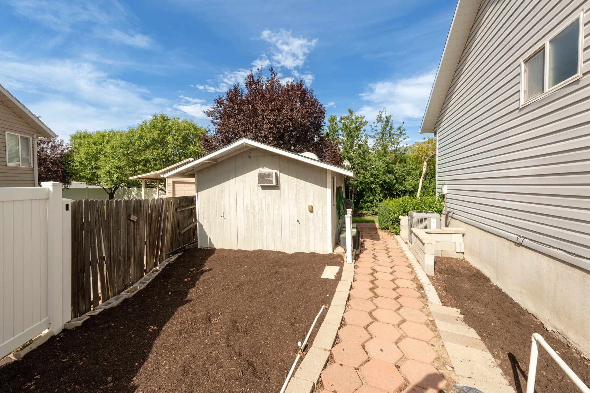 Detached storage shed with window air conditioner