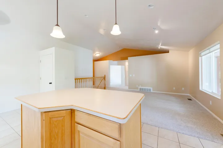 Kitchen island with light wood-finish cabinetry and solid surface countertop