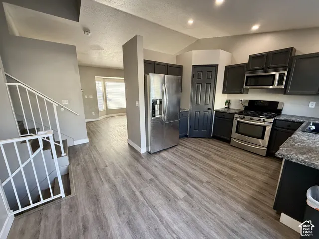 Kitchen with dark cabinetry, stainless steel appliances, and a gas range
