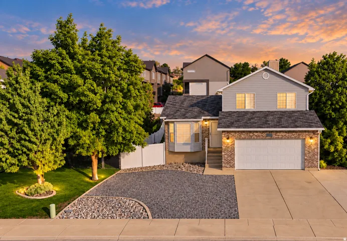 Two-story residence featuring a combination siding and brick facade, an attached two-car garage, and a bay window