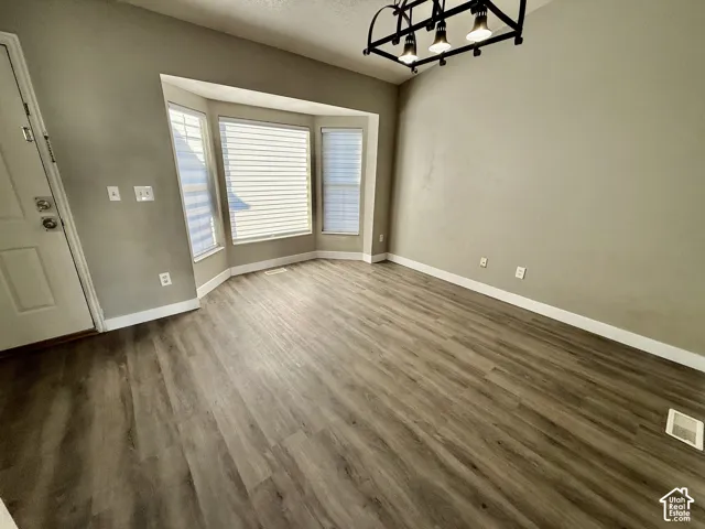 Bay window with multiple panels, wood-finish flooring, and a ceiling-mounted light fixture