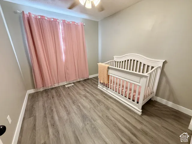 Wood-finish flooring, neutral wall tones, and overhead lighting