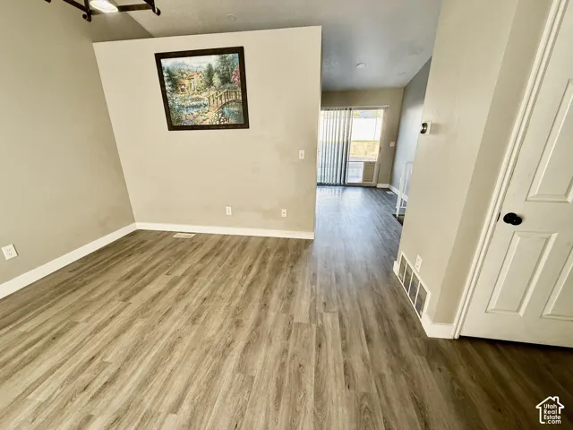 Wood-finish flooring throughout, with a paneled interior door and track lighting