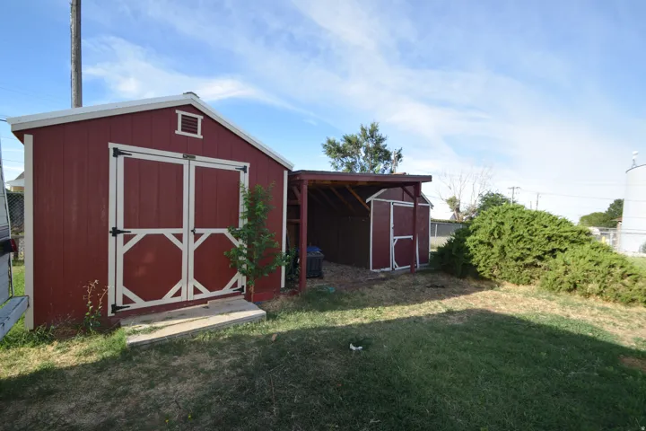 Red storage shed with white trim and double barn doors