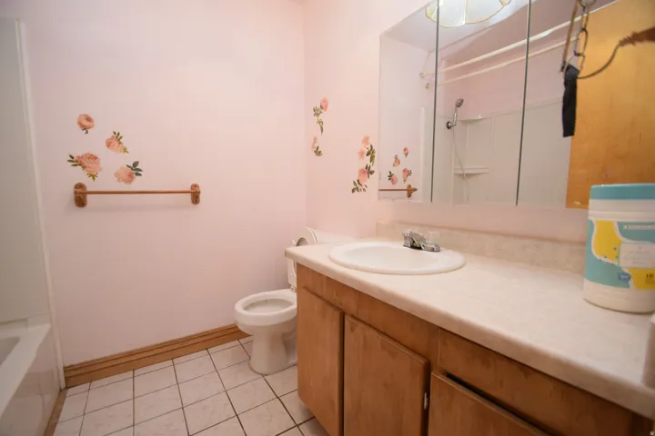 Bathroom featuring a vanity with wood-finish cabinetry, a single basin sink, and a mirrored medicine cabinet