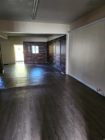Wood-finish flooring throughout, complemented by a prominent wood-paneled accent wall