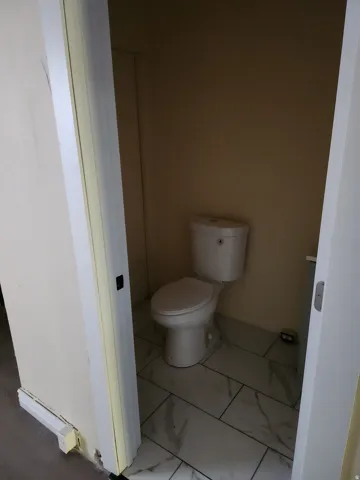 White toilet with a tank, set on a tiled floor
