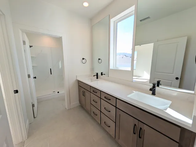 Primary bathroom with Dual vanity with a white countertop and rectangular vessel sink, complete with matte black fixtures