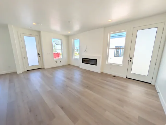 Recessed lighting illuminates the wood-finish flooring