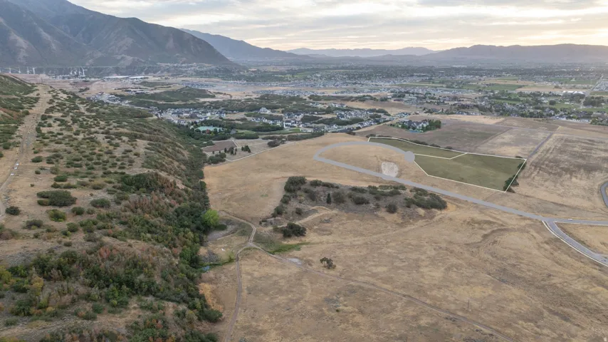 Expansive land parcel featuring existing road infrastructure and a distant mountain backdrop