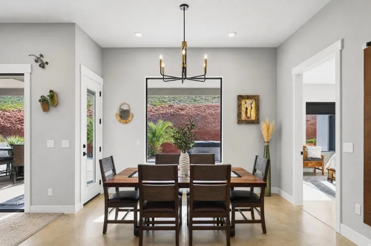 Spacious dining area featuring a modern chandelier, a large picture window, and light-toned flooring