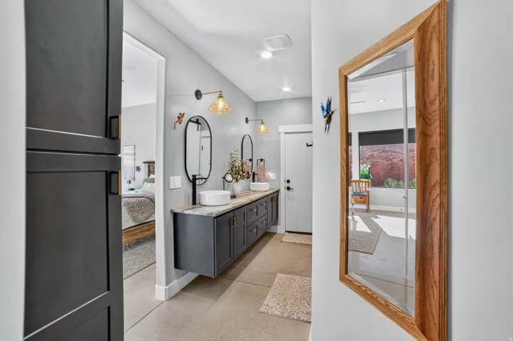 Dual floating vanities with vessel sinks, wall-mounted fixtures, and oval mirrors