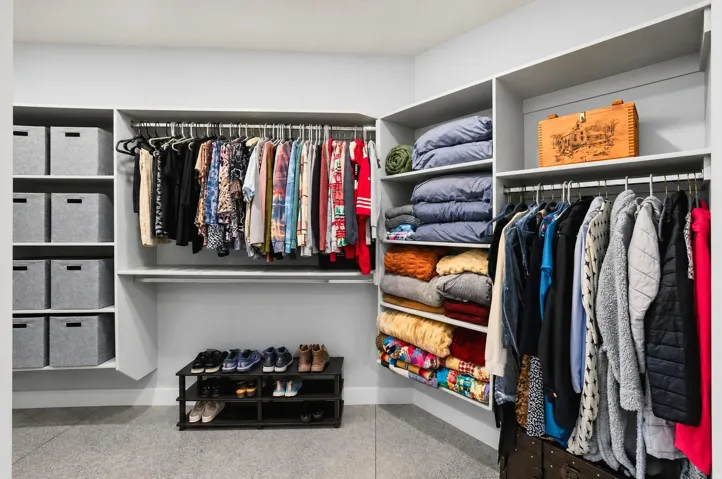 Custom closet system with multiple hanging rods, integrated shelving, and dedicated storage compartments