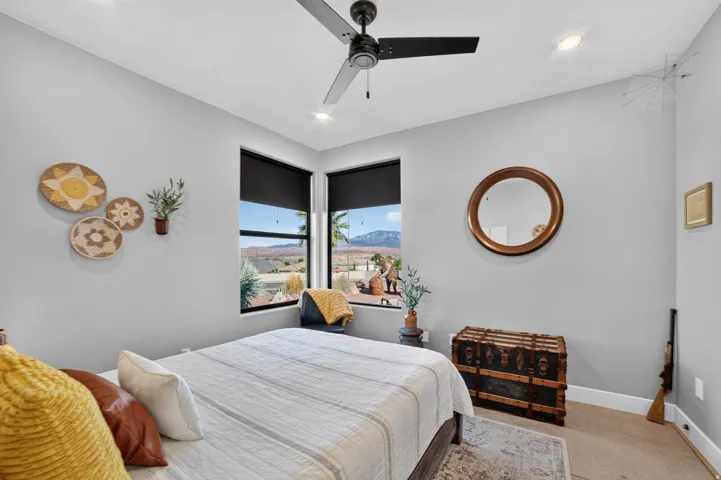 Corner windows with roller shades, recessed lighting, ceiling fan, and wood-finish flooring