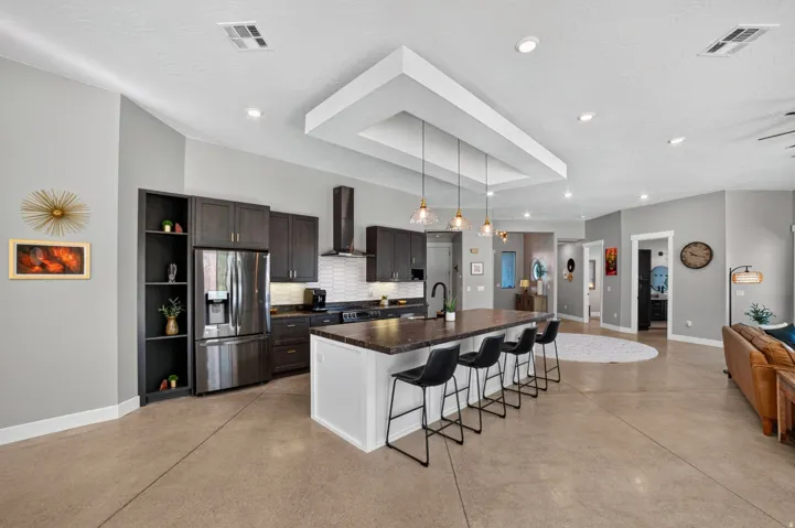 Kitchen featuring dark wood cabinetry, stainless steel appliances, and a central island with countertop seating