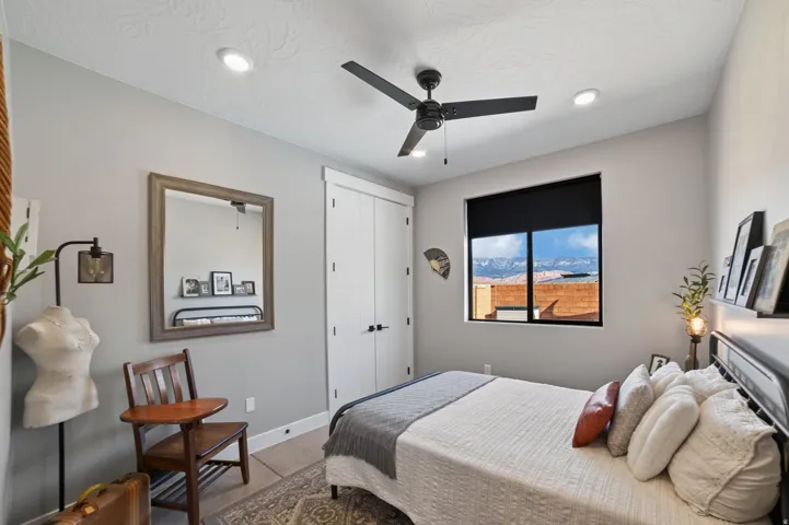 Recessed ceiling lighting, ceiling fan, and window with a dark roller shade