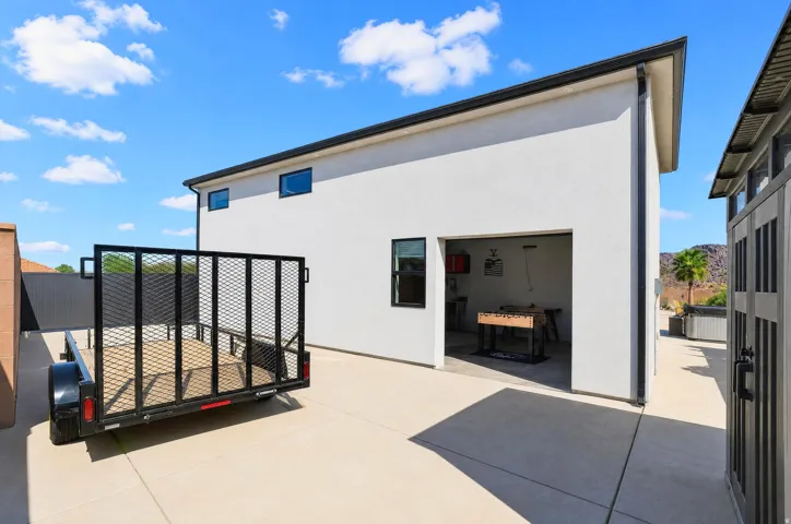White stucco exterior with black trim, concrete driveway, and garage space