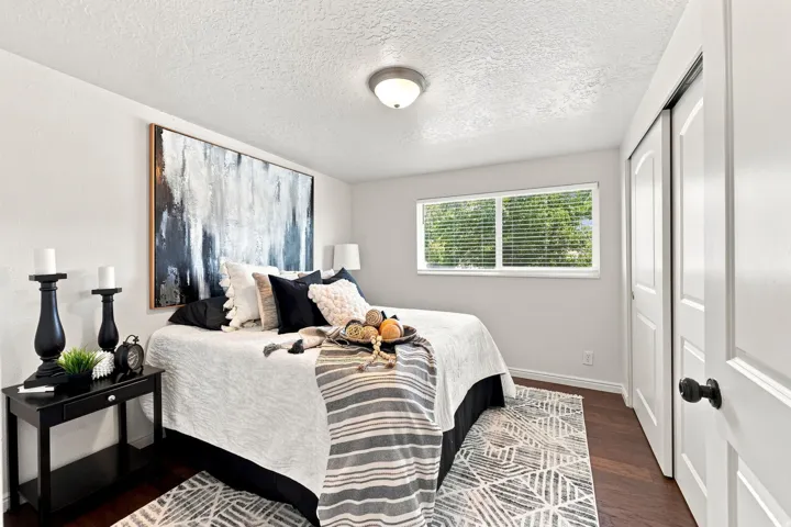 Hardwood-style flooring, white walls, and a single window with horizontal blinds