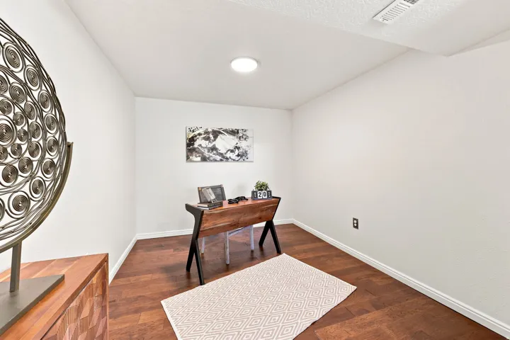 Recessed ceiling lighting, wood-finish flooring, and white walls